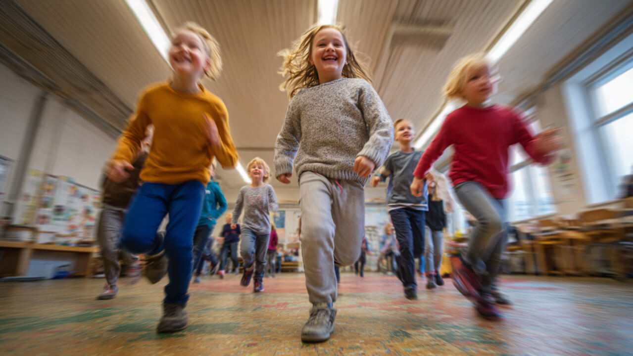 Skolbarn som springer över ett golv